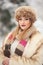 Attractive young Caucasian adult with brown fur cap. Beautiful blonde girl with gorgeous lips and eyes wearing fur hat, outdoor