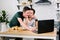 Attractive young Caucasian gay couple, homosexual couple, in kitchen, embracing and having breakfast at the dinner table