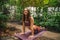 Attractive young caucasian woman doing yoga at botanical garden