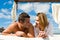 Attractive young couple on chill out bed under blue summer sky