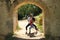 Attractive young couple dancing sensual bachata under an ancient stone arch in an outdoor park. Latin, sensual, folkloric, urban