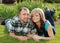 Attractive young couple lying on grass together in nature