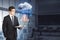 Attractive young european businessman with laptop standing in blurry office interior with abstract hologram raining cloud and mock