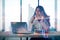 Attractive young european woman silhouette sitting at desk with laptop on blurry city background with forex chart. Success,