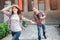 Attractive young female tourist walk forward. She smiles. Young woman hold boyfriend`s hand and hat on here head at the