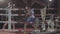 Attractive young fighter male boxer athlete training workout practicing punch hook kick with personal coach boxing ring