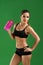 Attractive young fitness woman with a sports bottle on green bac