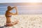 Attractive, young girl in a bathing suit sitting on the beach and sunbathing