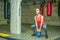 Attractive young girl squats workout in the gym for legs muscles with heavy kettle bell weight, real people indoor training