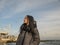 Attractive young girl stands on the seashore and the sky. sea â€‹â€‹gulls soar in the sky