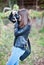 Attractive young girl taking pictures outdoors. Cute teenage girl in blue jeans and black leather jacket taking photos in park