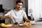 Attractive young man applying jam onto toast on weekend morning