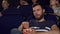 Attractive young man eating popcorn during boring movie at the cinema