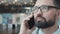 Attractive young man with glasses and beard, answers the phone