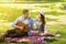 Attractive young man singing romantic song to his beloved girl on summer picnic at park