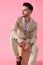 Attractive young man sitting on wooden box