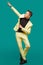 Attractive young man in suit dancing, having fun on mint background. Stylish outlook, successful businessman, happy