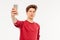 Attractive young man teenager makes selfie with smartphone