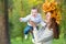 Attractive young mother holding baby girl in forest