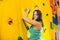 attractive young professional sport climber woman having training in the gym at artificial wall