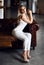 Attractive young smiling woman in smart casual white suit wear posing in creative