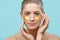 Attractive young woman applying gold collagen eye mask. Beauty products concept.