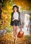 Attractive young woman in an autumnal shot outdoors. Beautiful fashionable school girl posing in park with faded leaves around