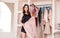 Attractive young woman in black pajamas is choosing clothes in light room and look at camera. Girl in wardrobe