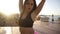Attractive young woman in black sporty bra and pink shorts fluttering long hair. One girl dancing on open place with