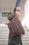 Attractive young woman with brown leather rucksack on stairs