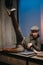 Attractive young woman with brunette hair posing with one leg up indoors wearing a stylish newsboy hat.