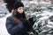 Attractive young woman choose Chrisstmas tree on outdoor trees farm. Woman smell fir tree