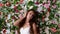 Attractive young woman in classy white dress on flower wall