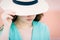 Attractive young woman covers her face with a hat, only reveals her lips