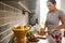 Attractive young woman cutting pepper and preparing vegan salad in the kitchen at home