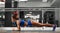 Attractive young woman is doing plank exercise while working out in gym
