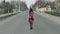 Attractive young woman in a dress with flowers walking on the highway