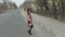 Attractive young woman in a dress with flowers walking on the highway