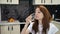 Attractive young woman drinking water from a glass in the kitchen early in the morning. Nutrition concept.