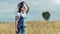 Attractive young woman enjoying magnificent nature standing in field of wheat or dried grass