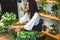 Attractive young woman florist is working in a flower shop.