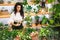 Attractive young woman florist is working in a flower shop.