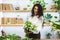 Attractive young woman florist is working in a flower shop.