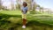 Attractive young woman golfer standing watching