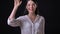 Attractive young woman greeting and inviting somebody, standing isolated on black background