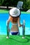 Attractive young woman in a hat down in the pool, summer photo.