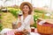 Attractive young woman having appetizer among tulip flowers. Fresh harvest with picnic and red wine in coutryside on spring time