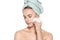 Attractive young woman with her hair wrapped in a towel, removing make up. Pretty girl with perfect complexion cleansing her face.