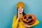 Attractive young woman hold big spooky pumpkin, look at aside, tell secret information, girl make loudspeaker share private