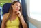 Attractive young woman looking through the train or bus window. Happy train passenger traveling sitting in a seat and looking